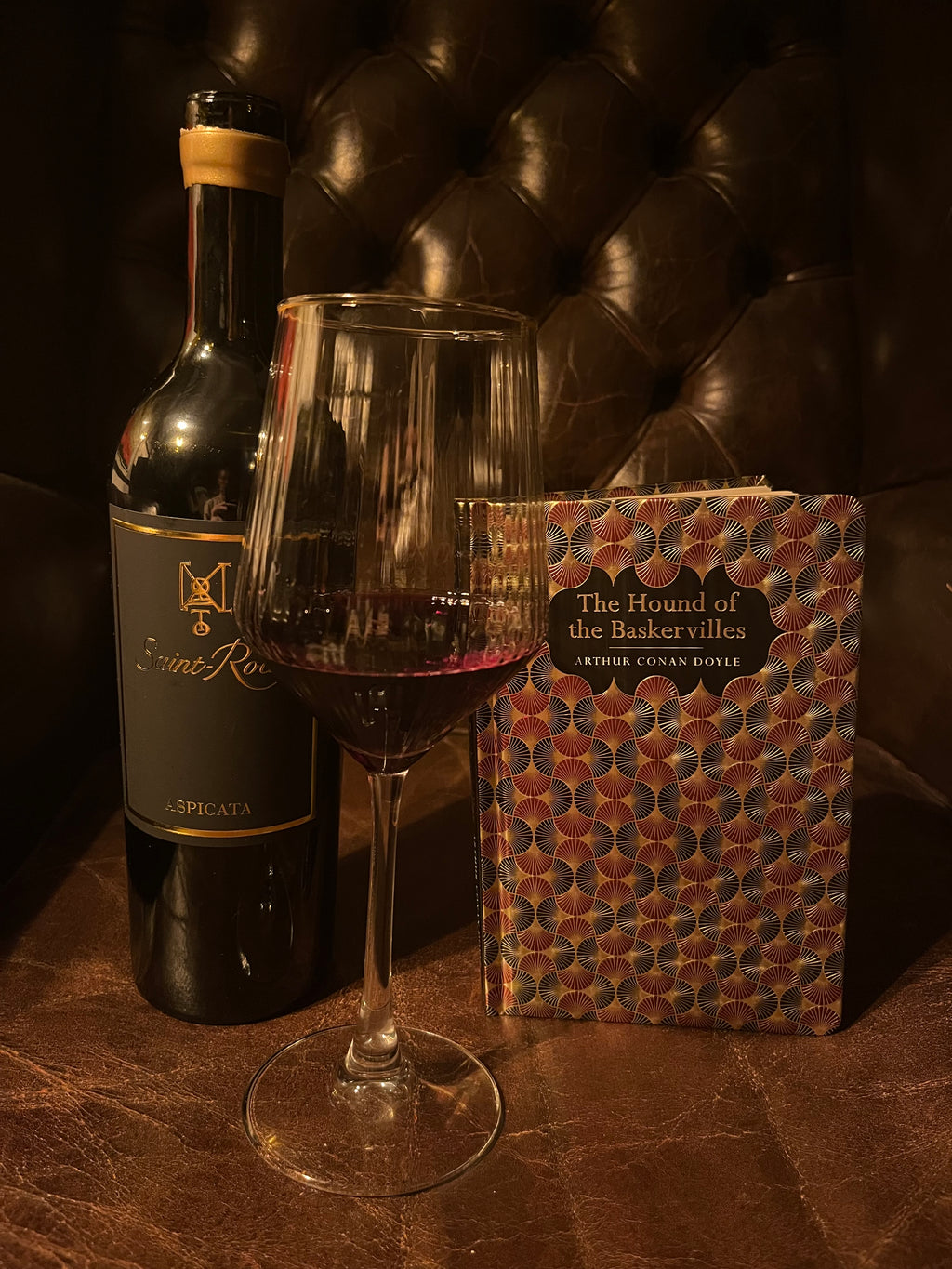 The Hound of the Baskervilles with Saint-Roch Aspicata wine bottle on leather