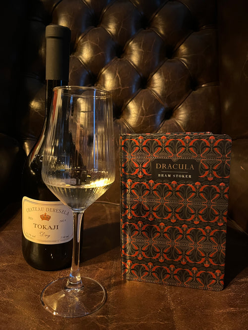 Dracula by Bram Stoker with Château Dereszla Tokaji Dry bottle and wine glass on Chesterfield leather