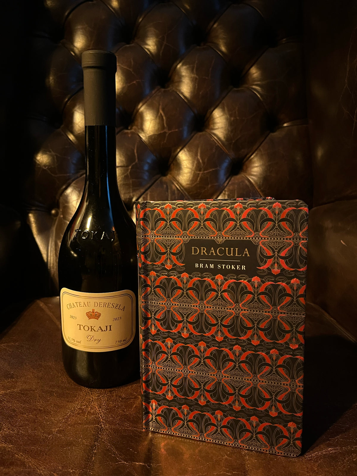 Dracula by Bram Stoker with Château Dereszla Tokaji Dry bottle on Chesterfield leather