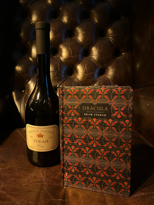 Dracula by Bram Stoker with Château Dereszla Tokaji Dry bottle on Chesterfield leather